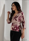 Woman wearing a floral blouse with a plain background