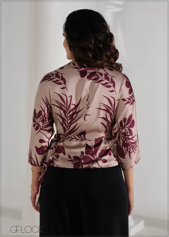 Woman wearing a floral blouse with a plain background